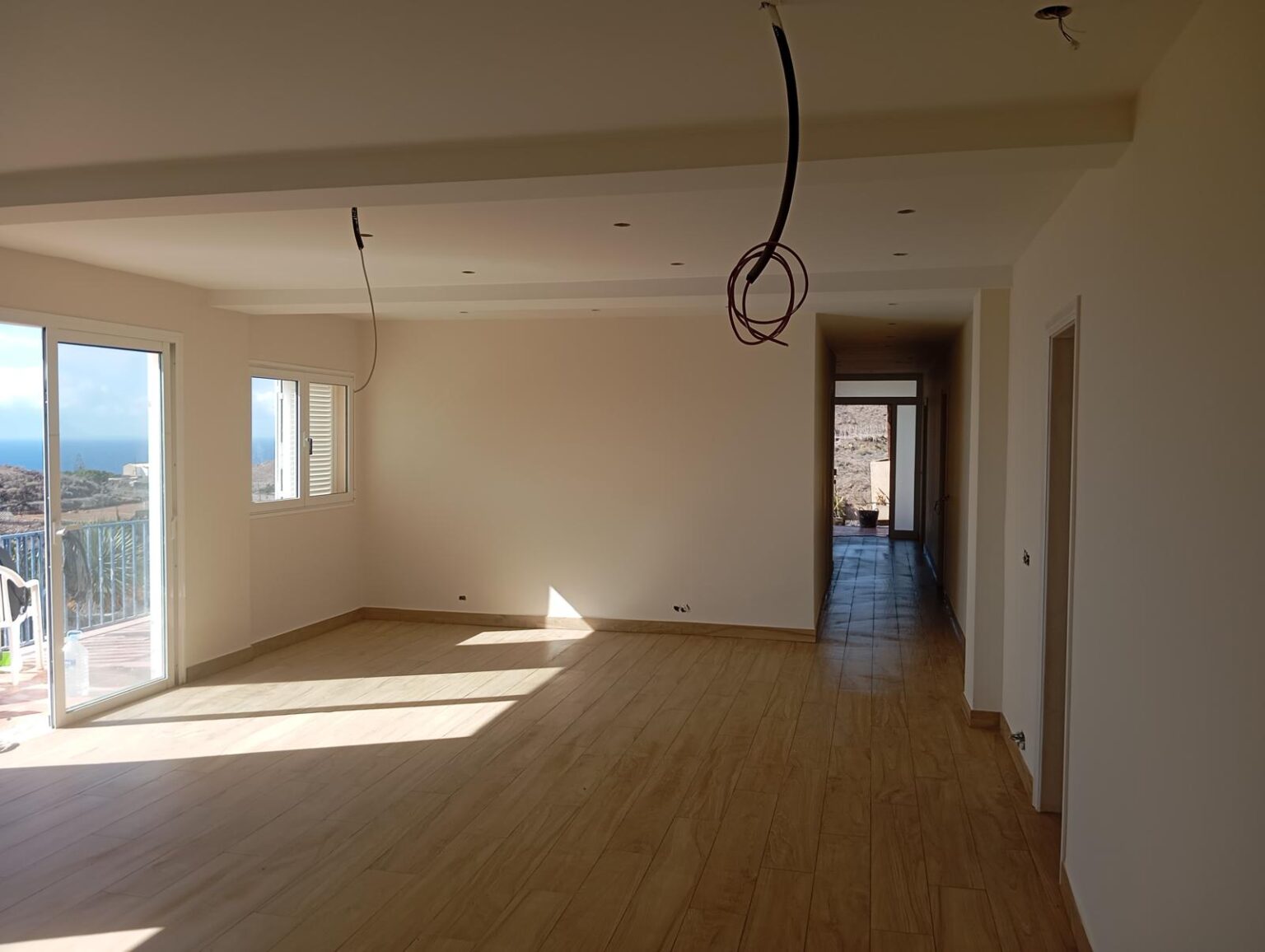 Colocación de suelo de tarima flotante imitación madera en salón por albañiles profesionales en Tenerife.